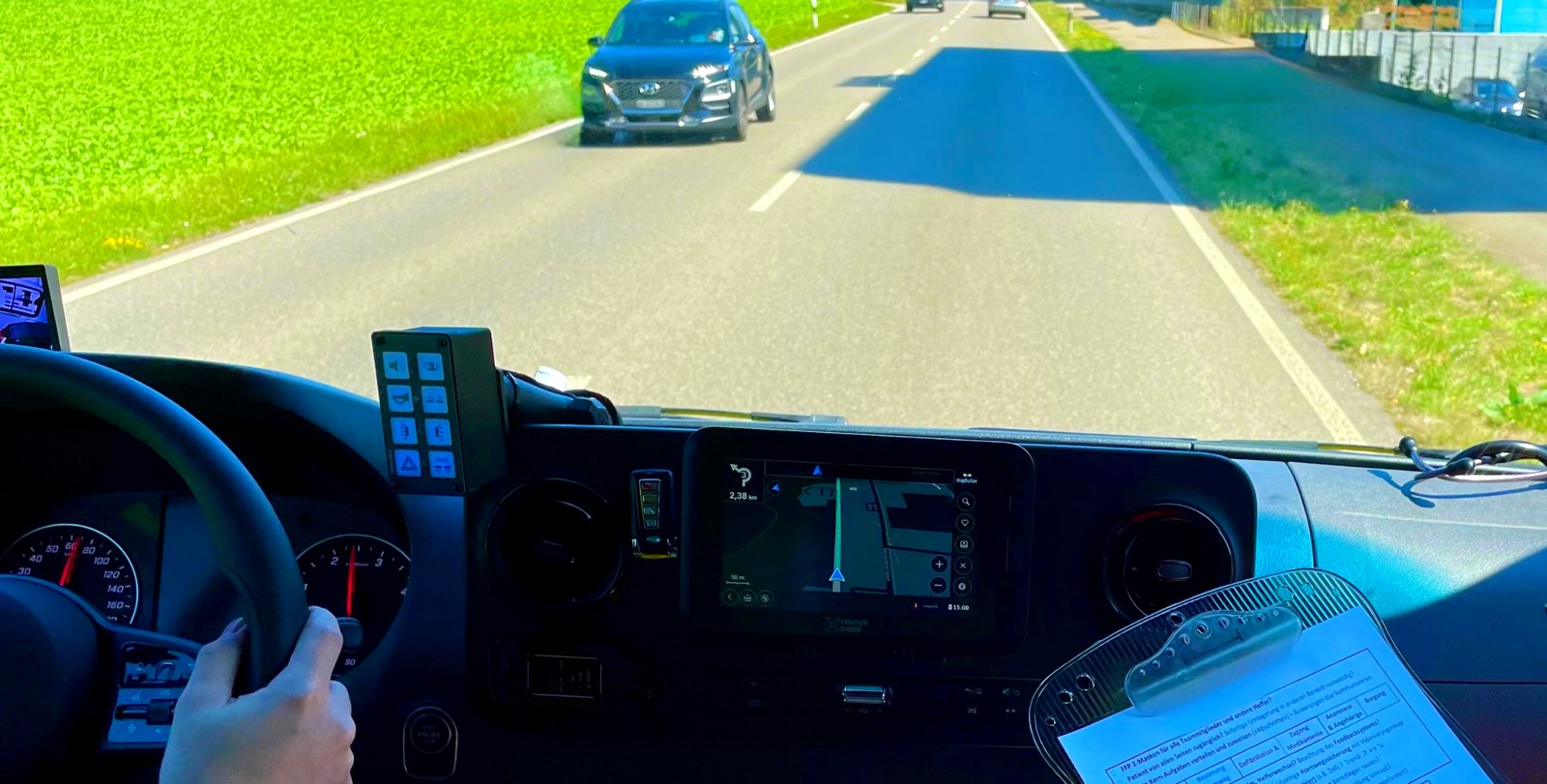 Blick aus dem Fahrerhaus eines Rettungswagens auf eine Landstraße mit entgegenkommendem Auto